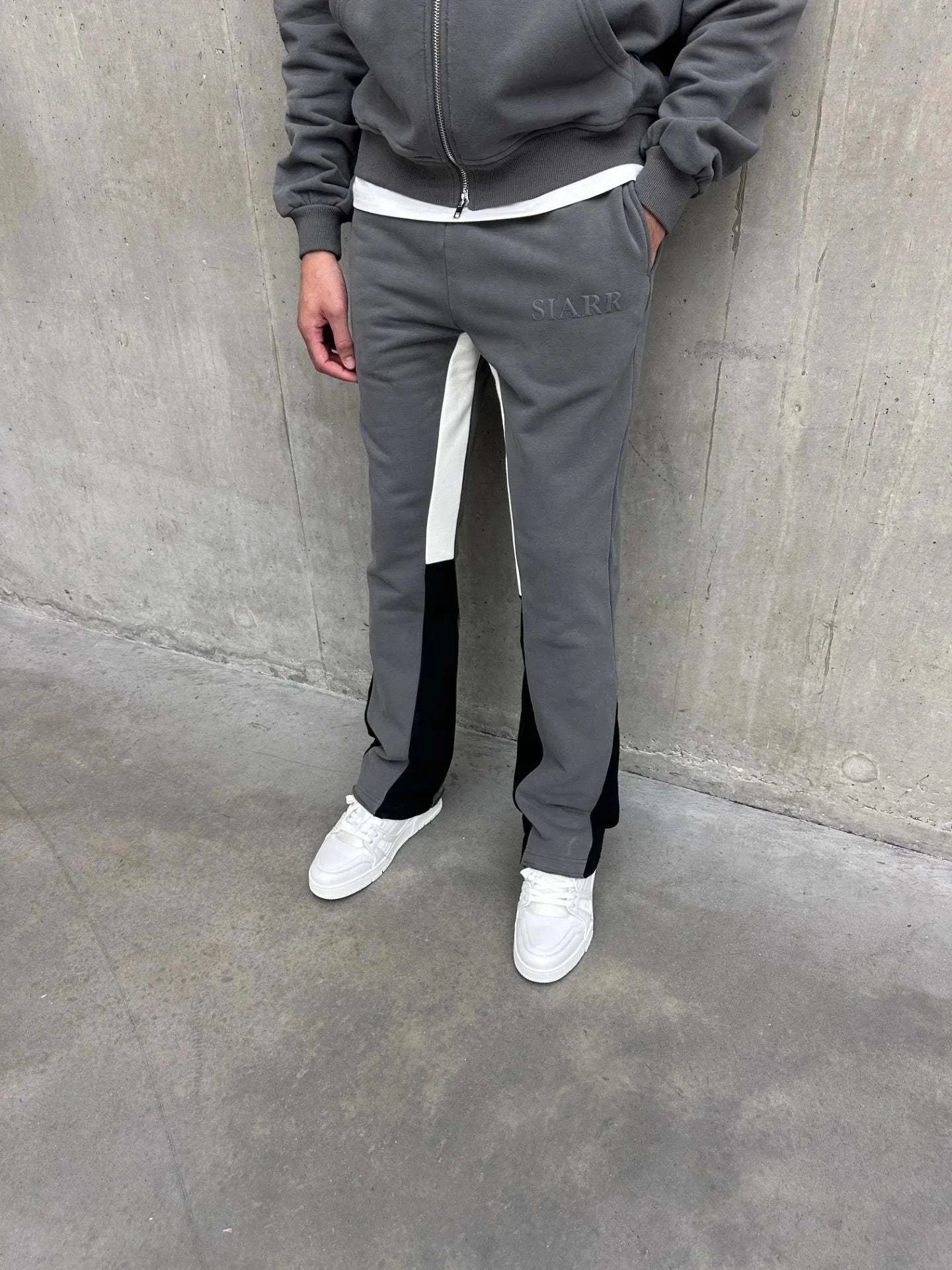 Siarr Flared Joggers in dark grey with black inside leg panelling and side slit pockets.
