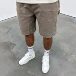 Beige Siarr Rio Shorts with rivet buttons, leather tab, and raw hem.
