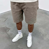 Beige Siarr Rio Shorts with rivet buttons, leather tab, and raw hem.