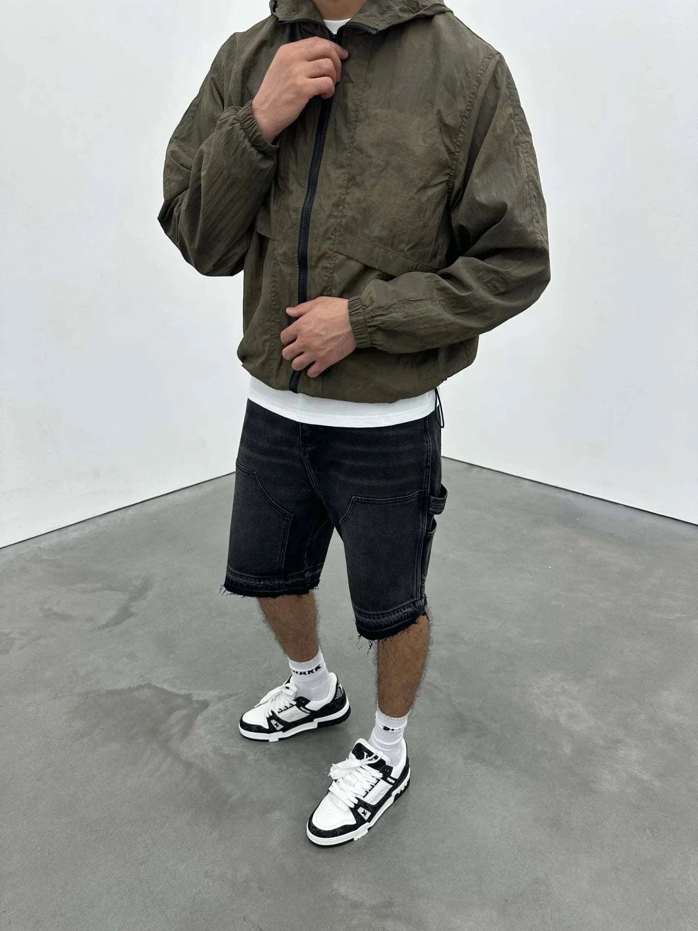 Siarr Venetian Windbreaker khaki nylon jacket with relaxed fit and side slit pockets worn with black shorts and white sneakers