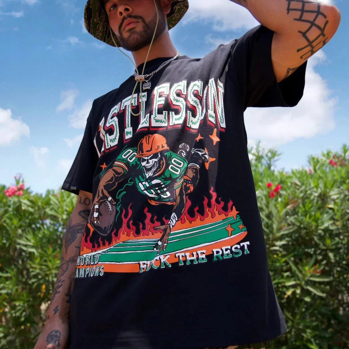 Last Lesson Touch Down black t-shirt with sports graphic design, worn by a model in a garden setting.