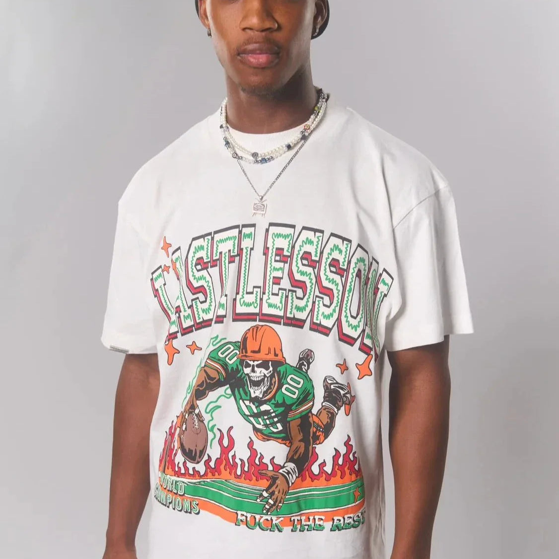 Man wearing a Last Lesson Touch Down white T-shirt with a football-themed graphic.
