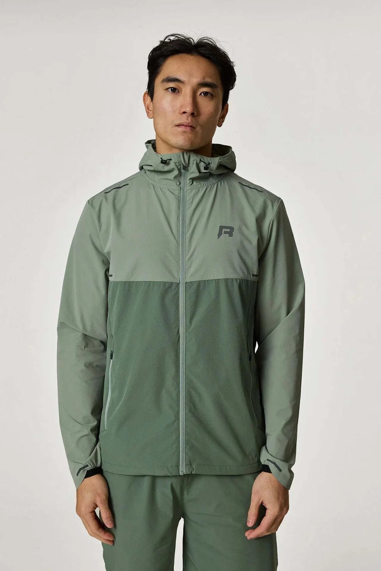 Reprimo Xcelerate Windbreaker in sage and botanical colors worn by a model.