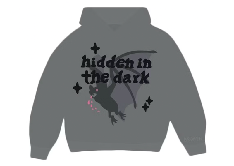 Hoodie with "Hidden in the Dark" text and graphic of a winged creature on a grey fabric.